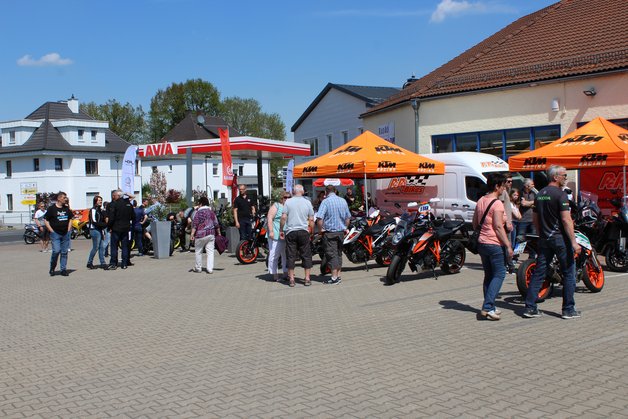 Besucher des Testivals, die Motorräder betrachten.