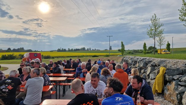 Besucher des Testivals sitzen auf Garnituren.